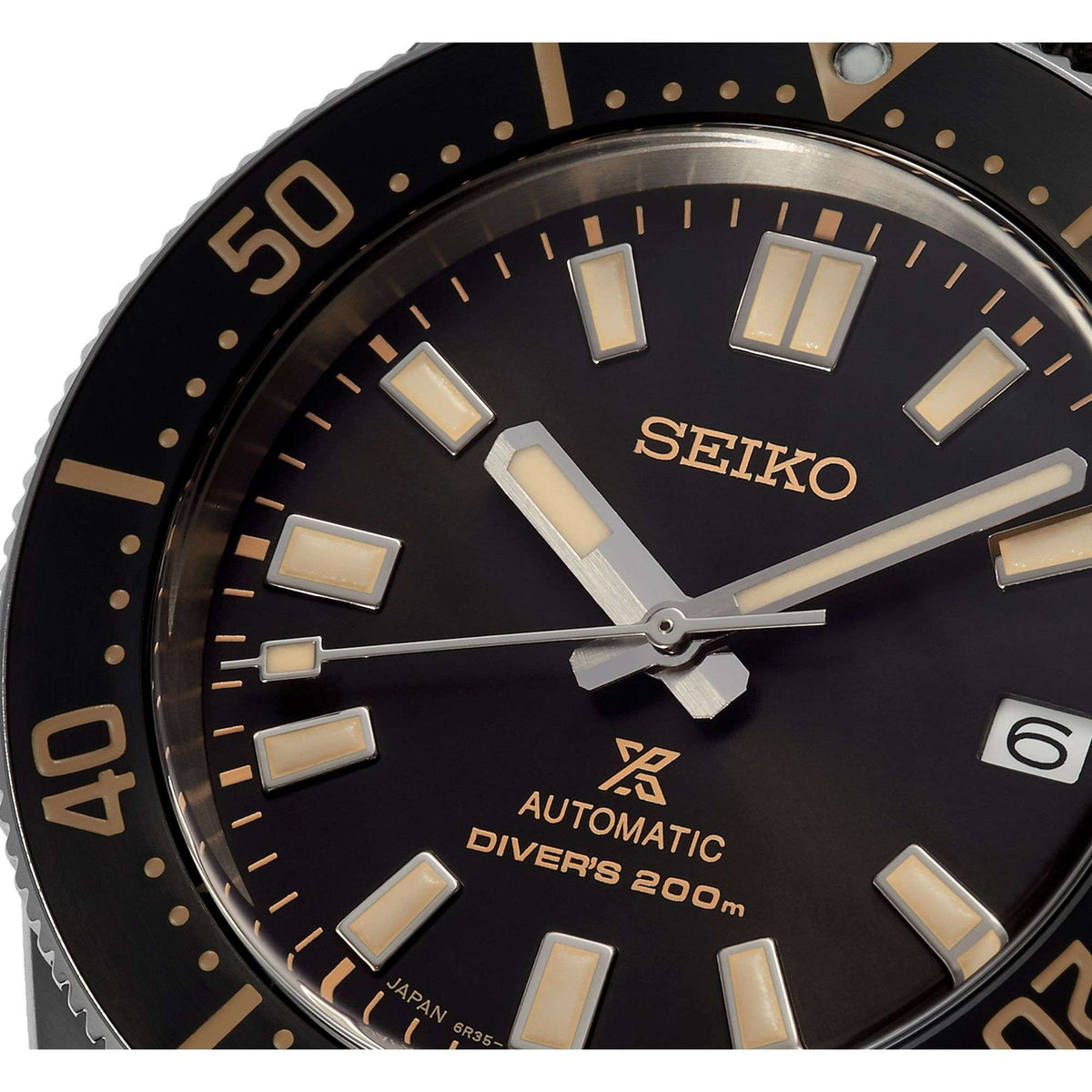 Men's Seiko diver watch dial close-up with gold markers, luminous hands, automatic text