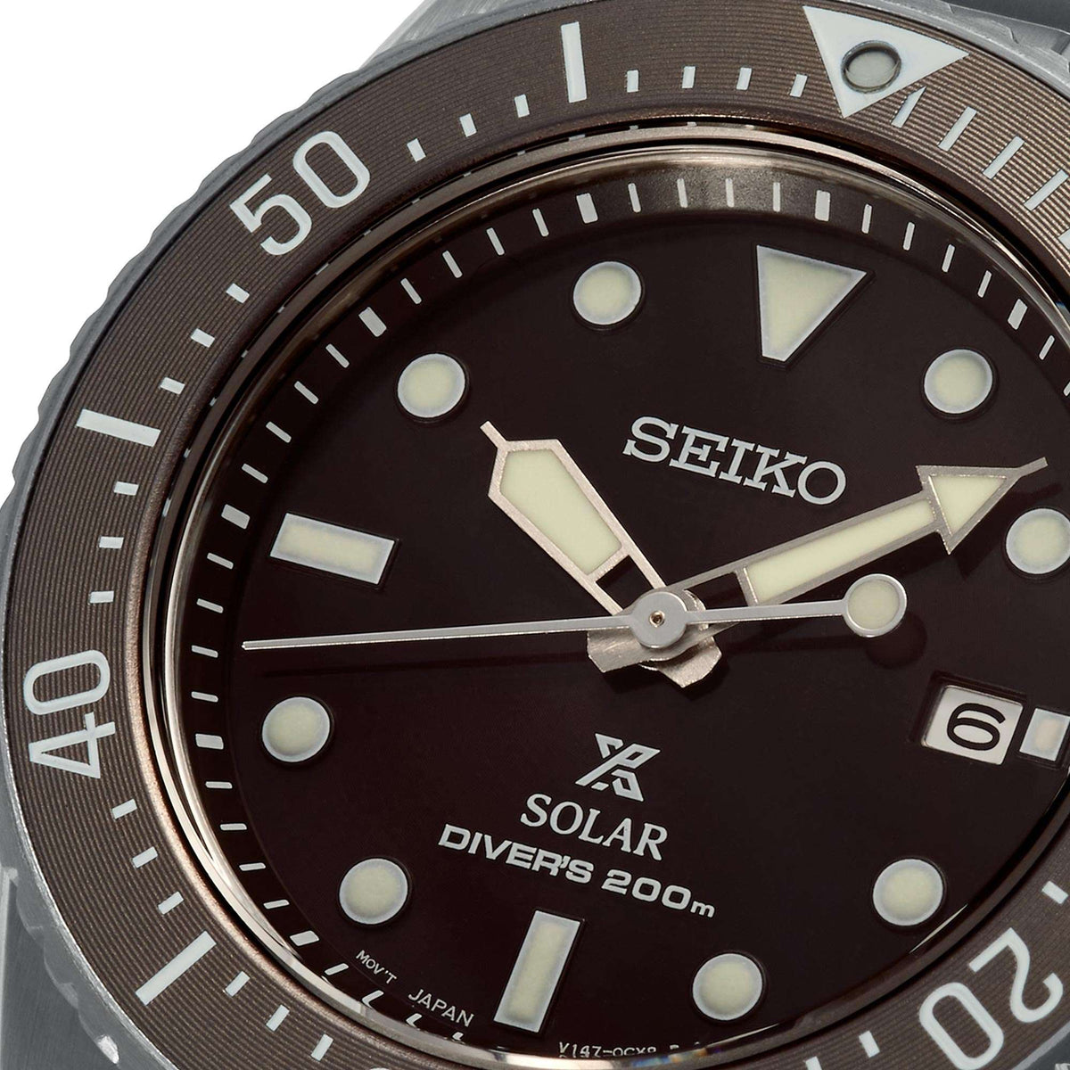 Seiko solar dial close-up with dark face, luminous markers, and date at 6 o'clock
