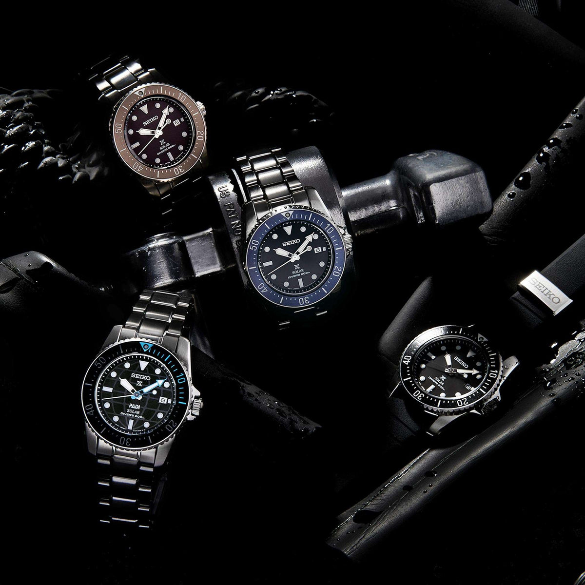 Set of Seiko solar diver watches with stainless bracelets, dark dials, and bezels