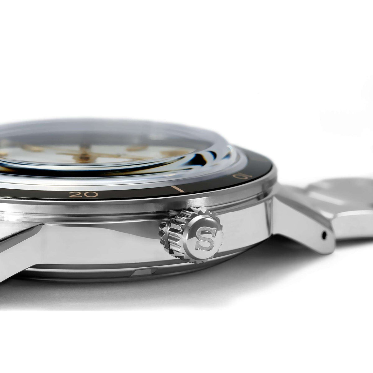 Stainless-steel watch case side with engraved S emblem and ridged crown