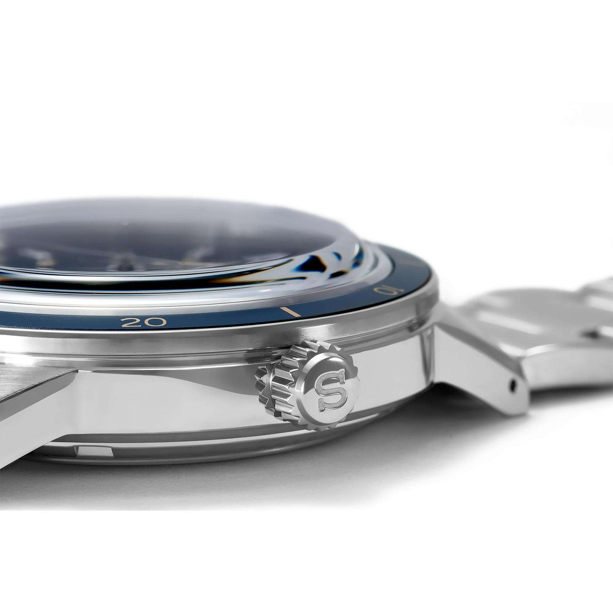 Stainless steel watch case side with crown and blue bezel ring, automatic model