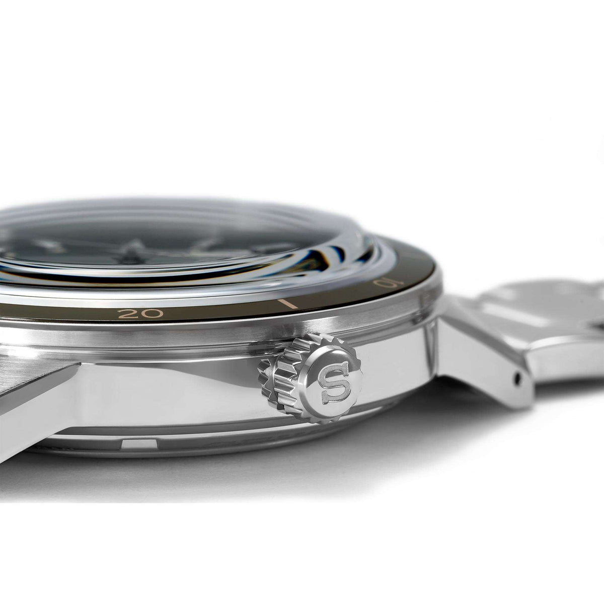 Stainless steel watch case close-up with crown and rotating bezel markings