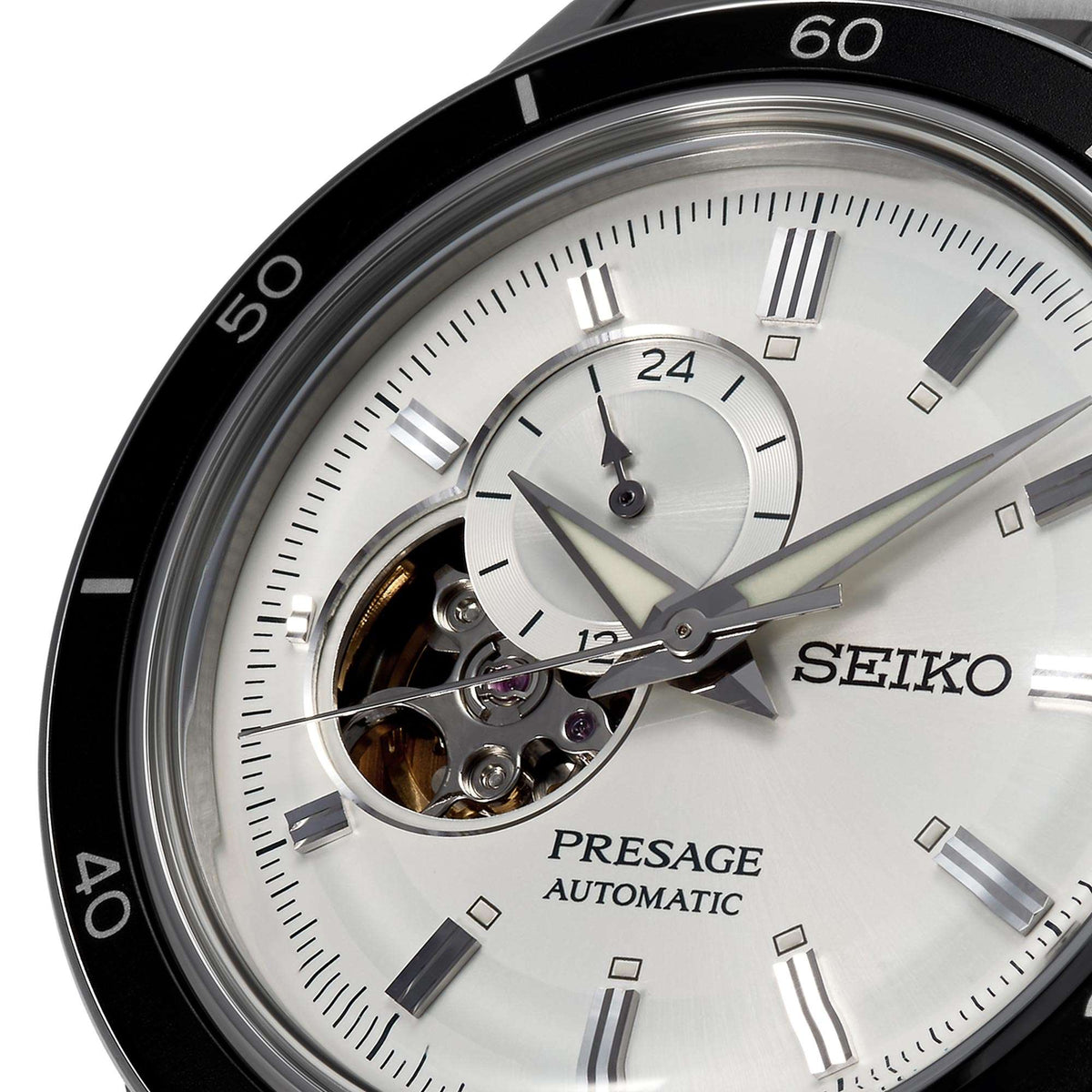 Silver watch dial close-up with open-heart window and visible automatic movement