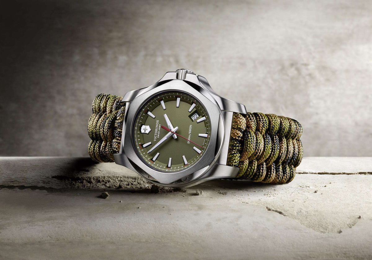 Men's wristwatch, side view: stainless steel case with dark green dial and green paracord strap