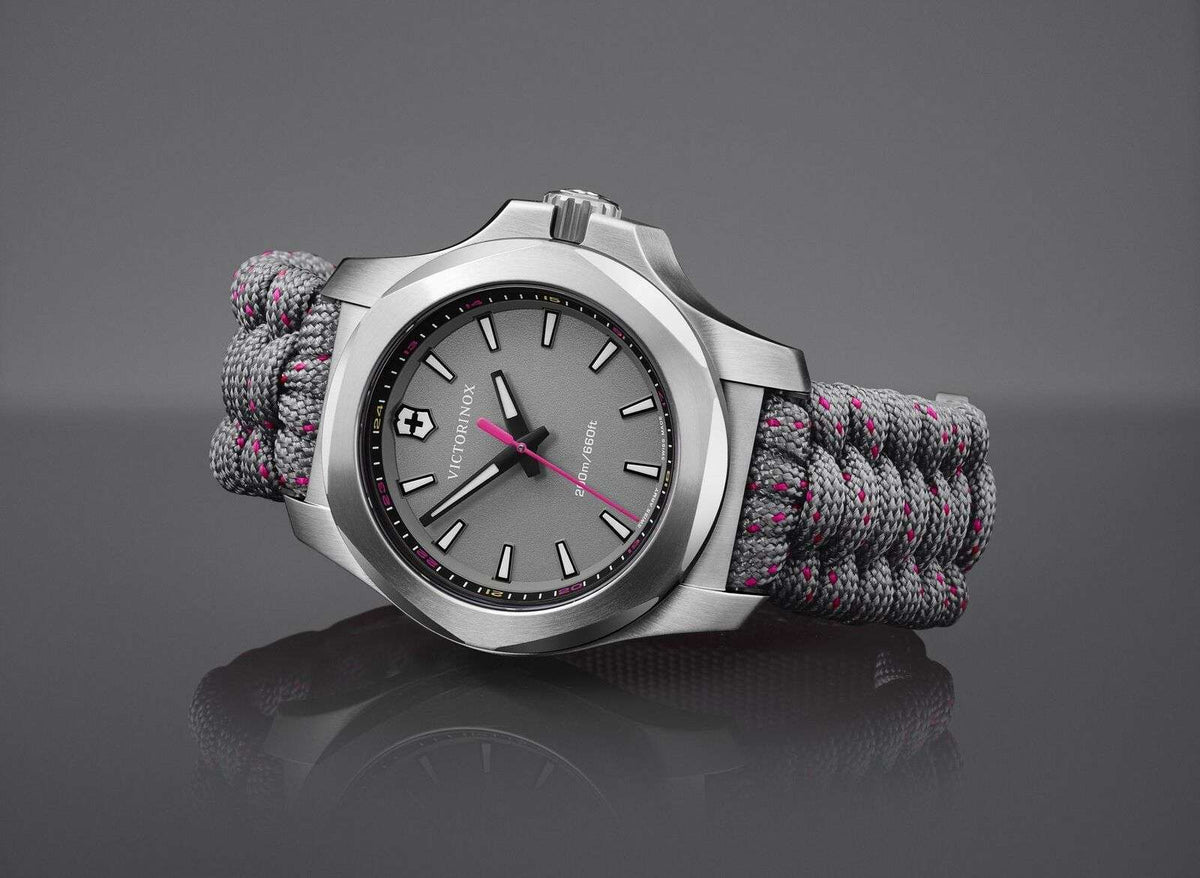 Silver stainless steel quartz watch with dark dial and gray paracord strap, angled perspective
