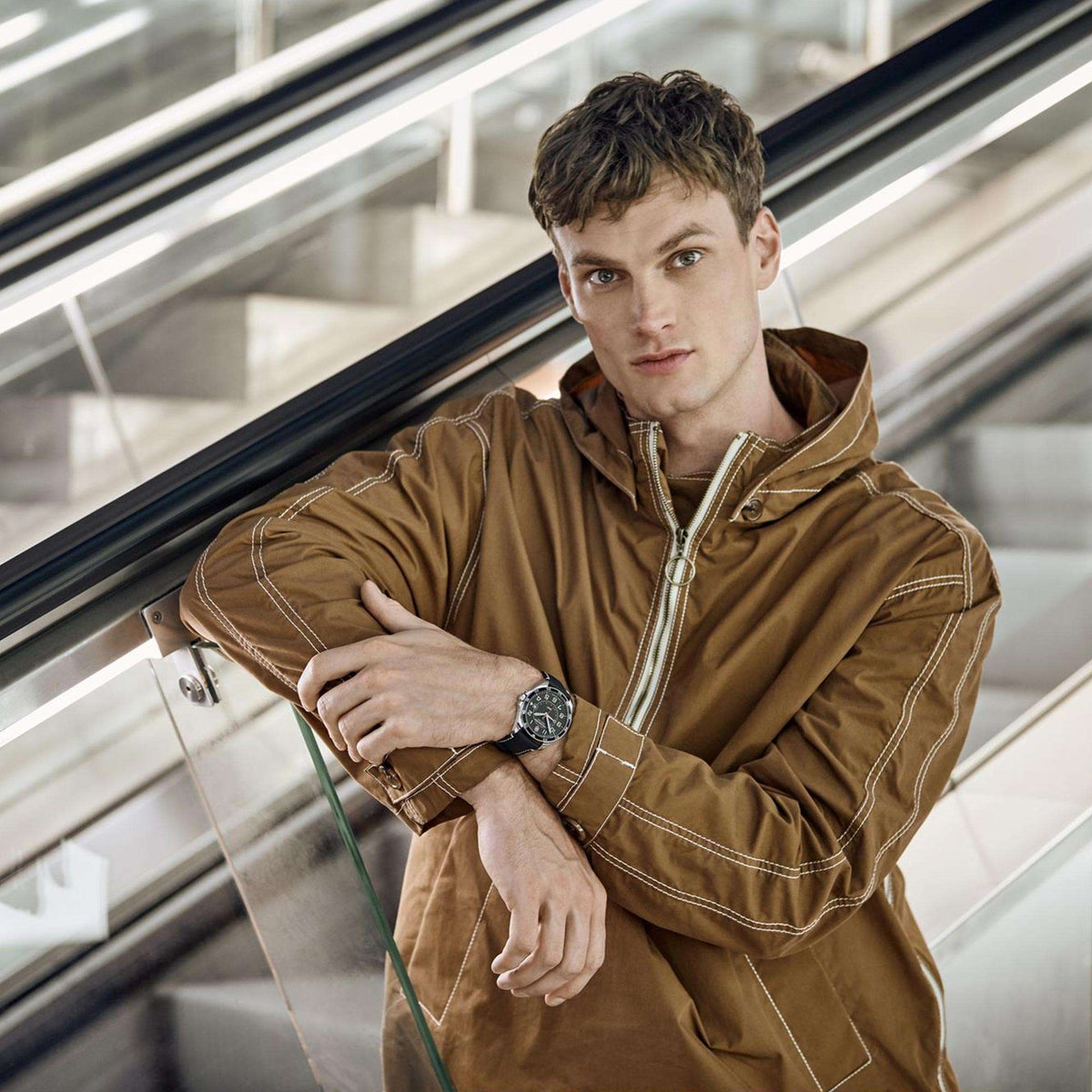 Men's wristwatch on model's wrist with black dial and leather strap