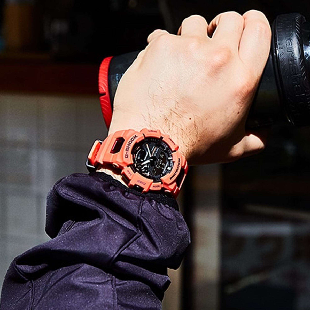 Casio G-Shock men’s quartz watch on wrist with red resin strap and black dial