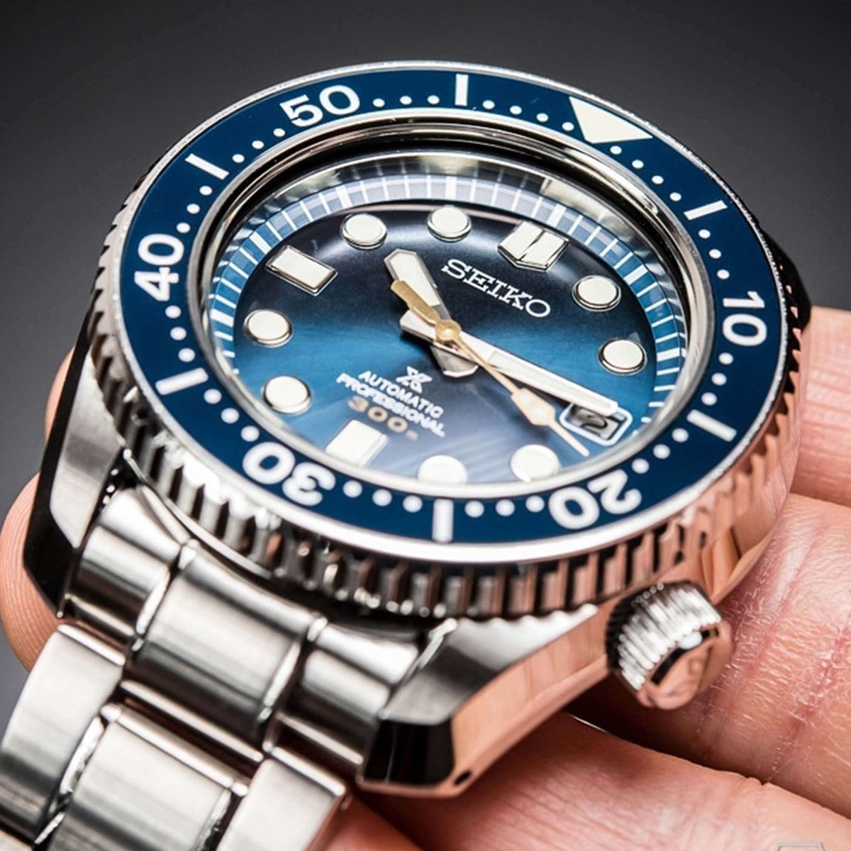 Blue dial automatic dive watch with knurled bezel, silver case, and metallic crown