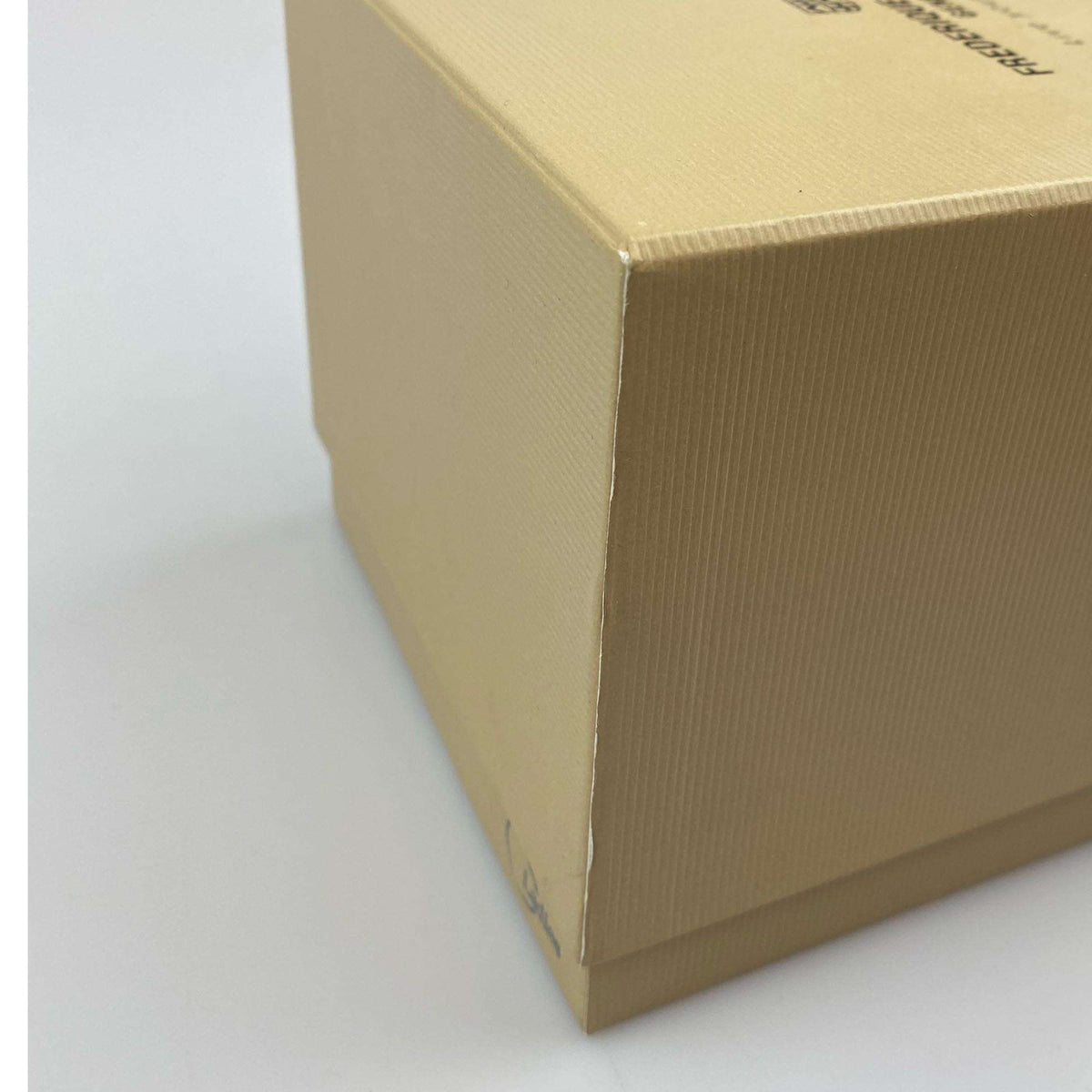Damaged cardboard watch box with visible corner fold and textured sides