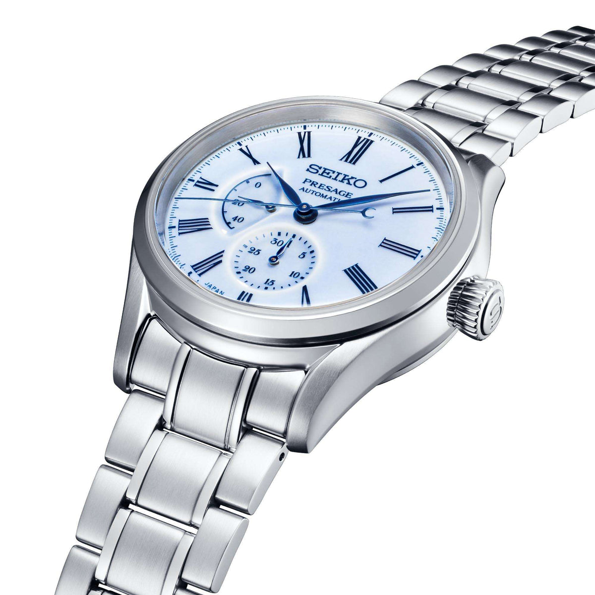 Men's automatic steel watch close-up with blue dial, Roman numerals, and subdials
