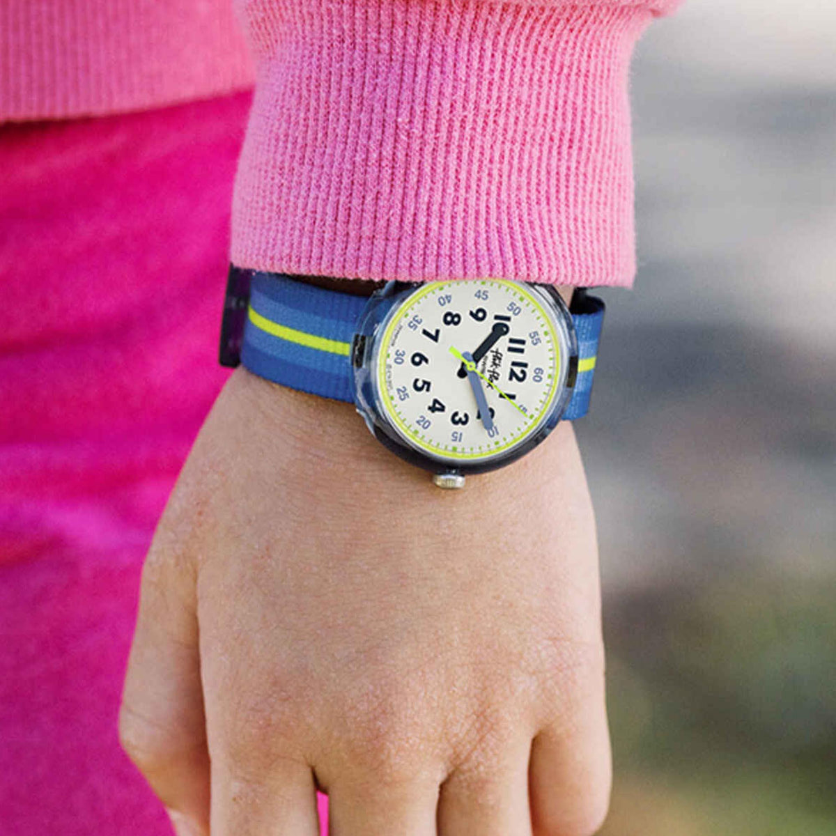 Boys' wristwatch on hand with blue dial and blue strap with green stripe