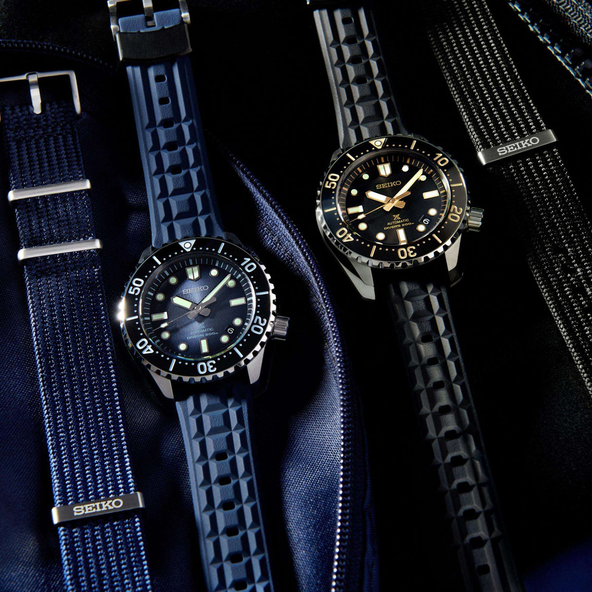 Two Seiko Prospex dive watches with blue fabric straps and black bezels
