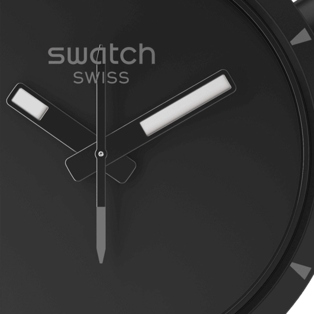 Close-up of black dial watch face with luminous hour markers and hands