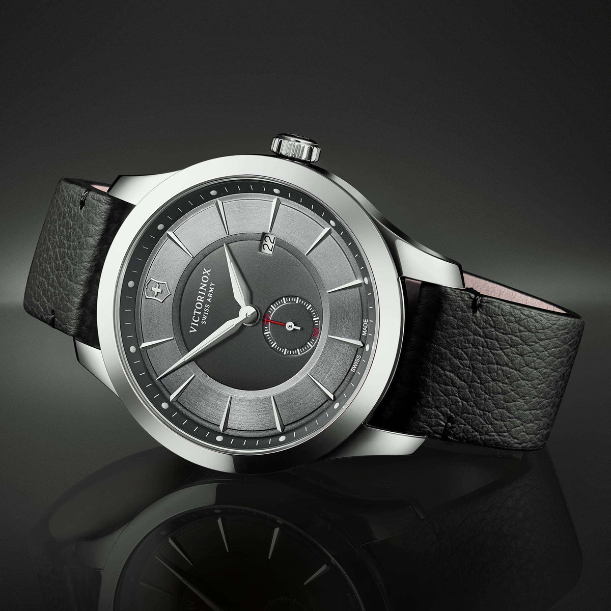 Men's Victorinox quartz watch angled view, black leather strap and grey dial, steel round case.