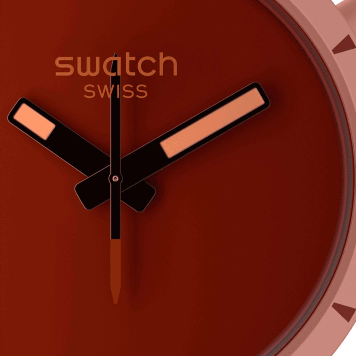 Red dial wristwatch close-up with three hands and light pink case