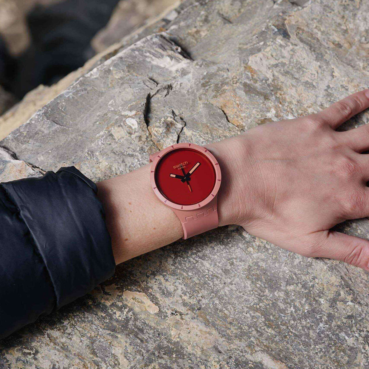 Red dial quartz watch worn with light pink silicone strap