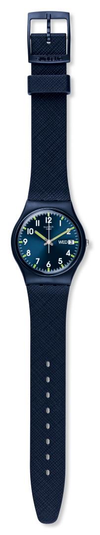 Men's blue dial Swatch watch on blue fabric strap, shown side with buckle clasp