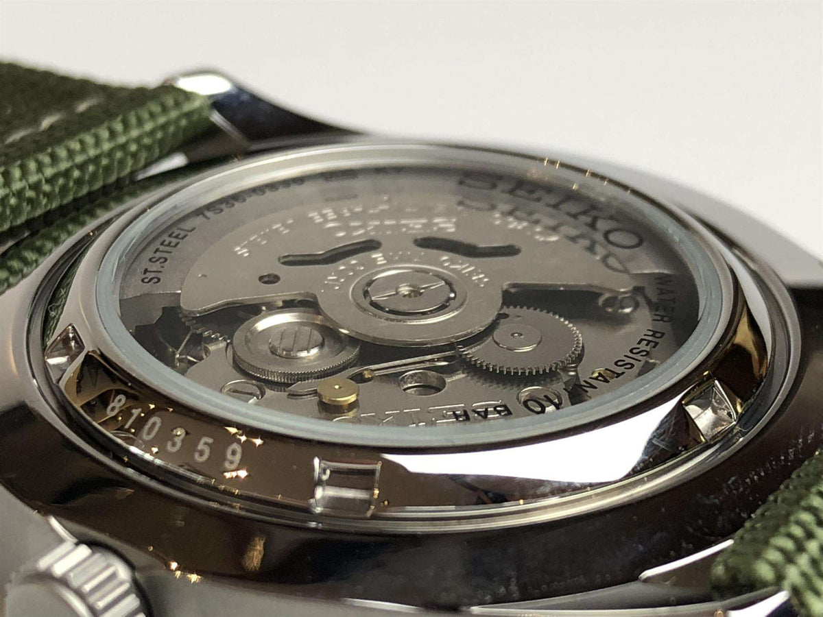 Men's automatic watch case back view showing mechanical movement through glass