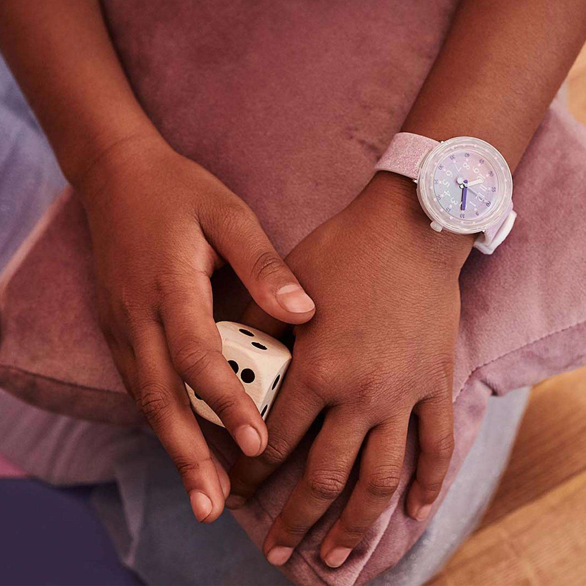 Girls wrist wearing pink dial quartz watch with white silicone band