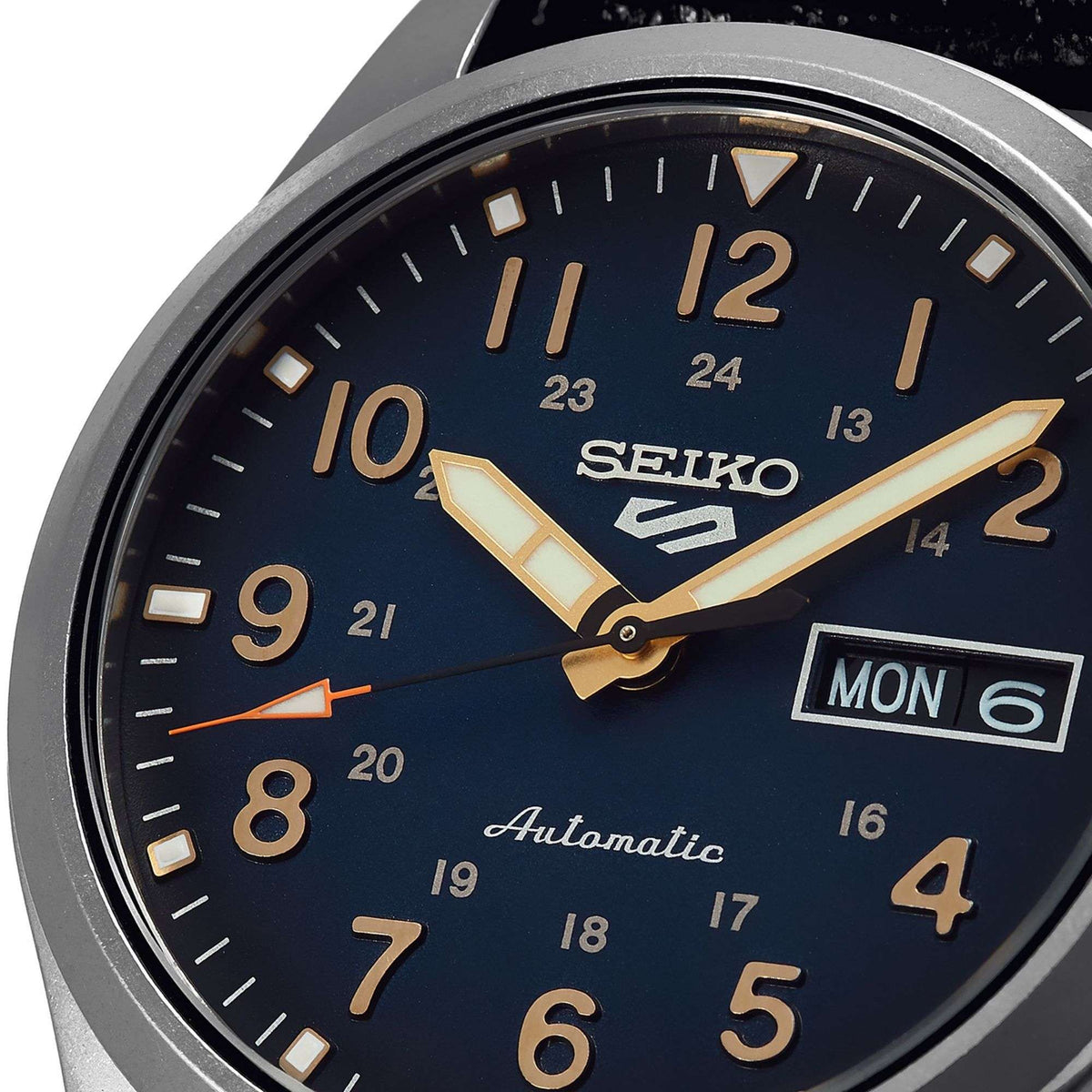 Men's automatic wristwatch close-up: blue dial with gold hands and MON date window