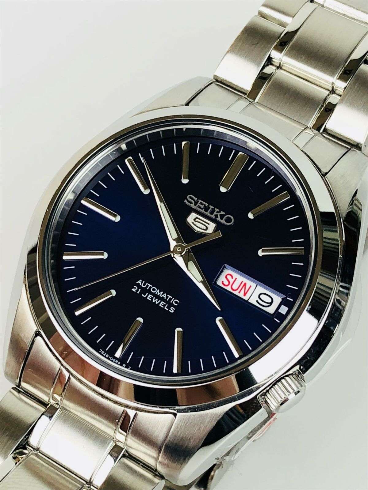 Close-up of Seiko SNKL43K1 blue dial showing baton markers, day-date window and "Automatic 21 Jewels" text