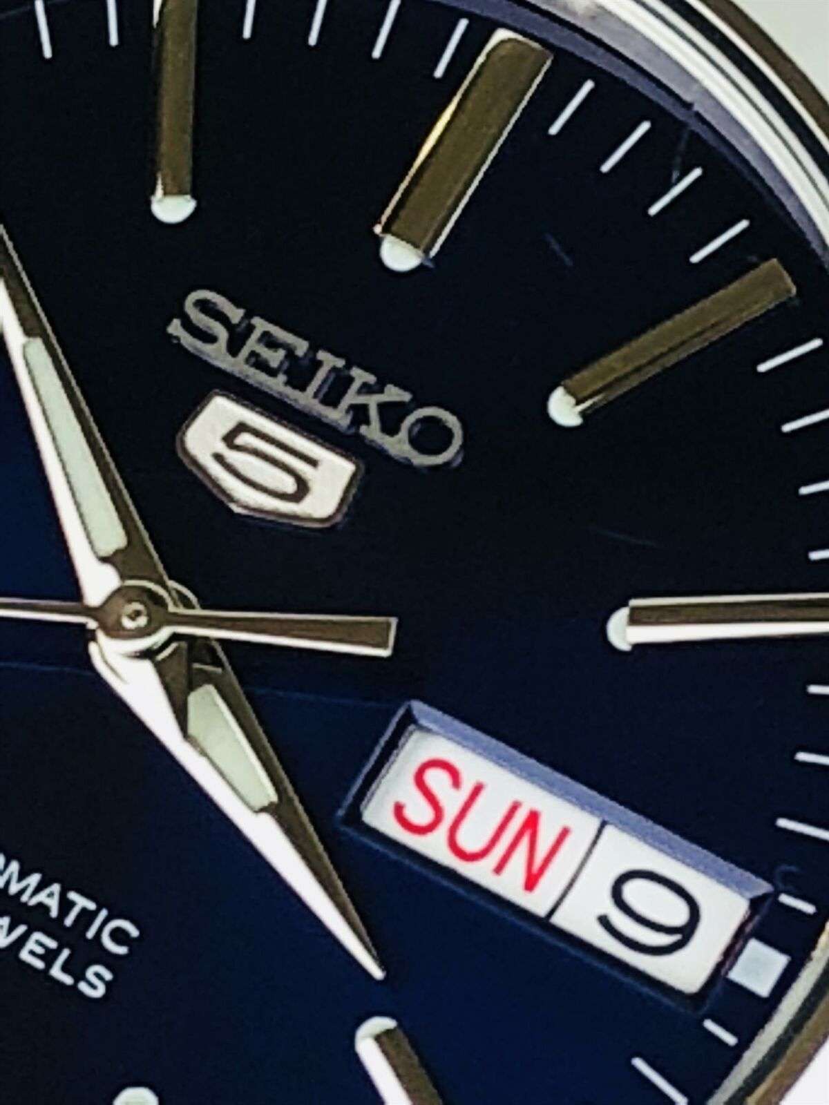Detailed close-up of Seiko 5 SNKL43K1 blue dial with day-date complication and logo