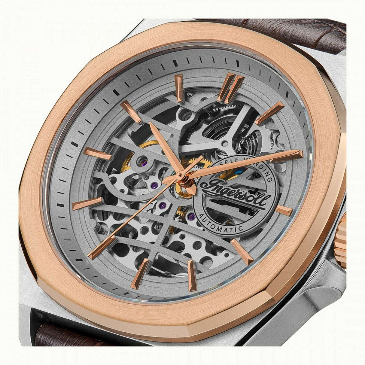 Close view of grey skeleton dial with orange gear details and exposed automatic mechanism