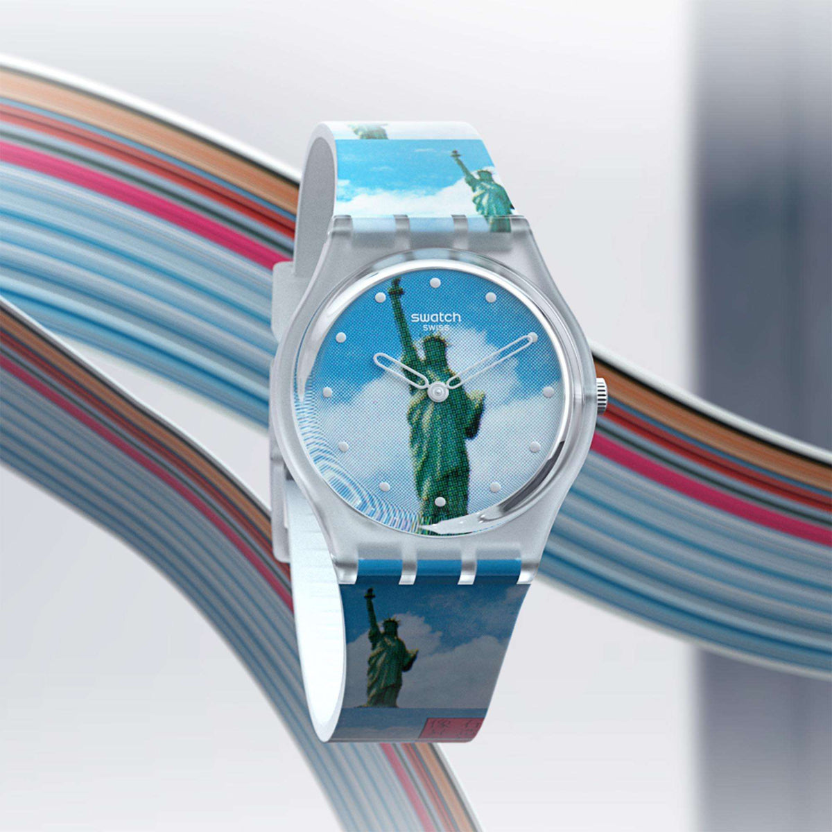Swatch watch with clear bezel, blue dial and Statue of Liberty motif on silicone strap