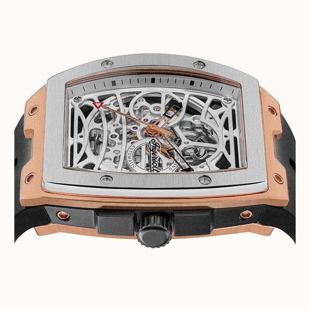 Automatic skeleton watch dial close-up in steel frame with rose-gold case sides.