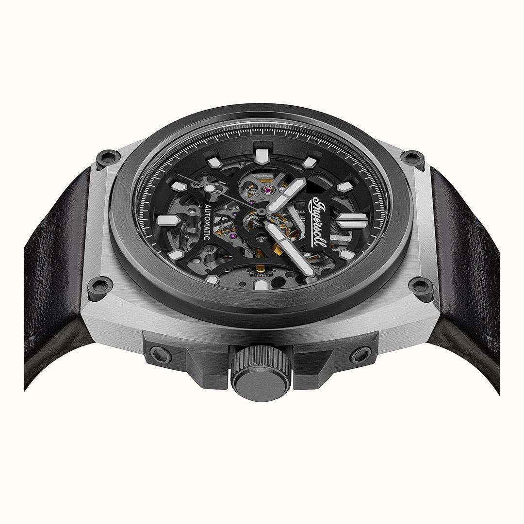 Automatic skeleton watch front with black dial, steel case, and black leather straps