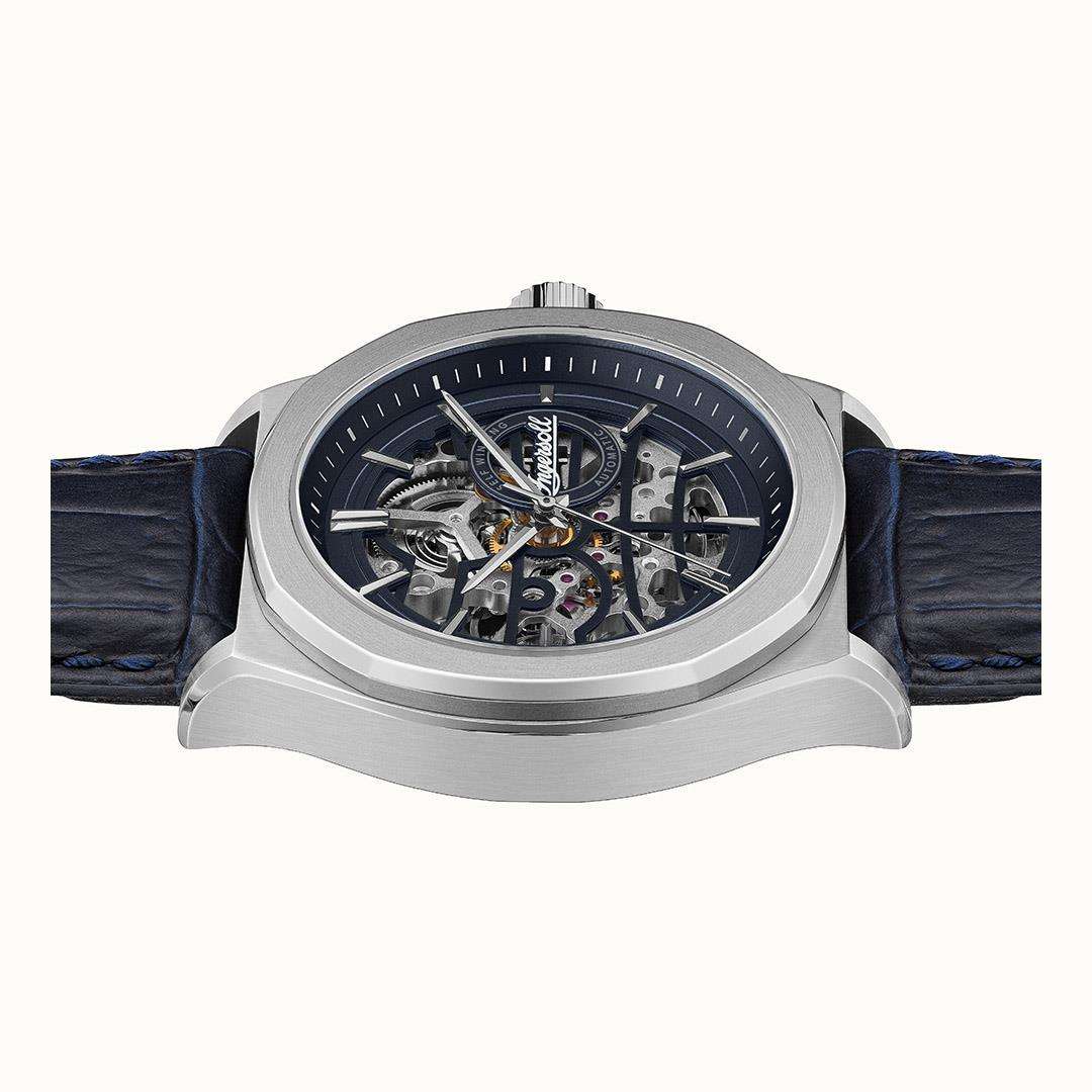 Men's automatic watch top view showing exposed gears through the round navy dial.