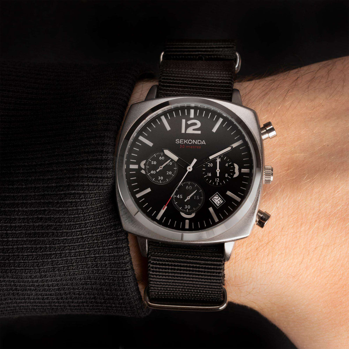 Men's Sekonda watch on wrist with black dial, chronograph subdials, and black strap.
