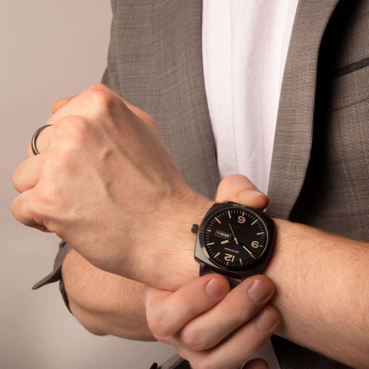 Men's black dial watch worn on wrist with black strap and SAT 25 window