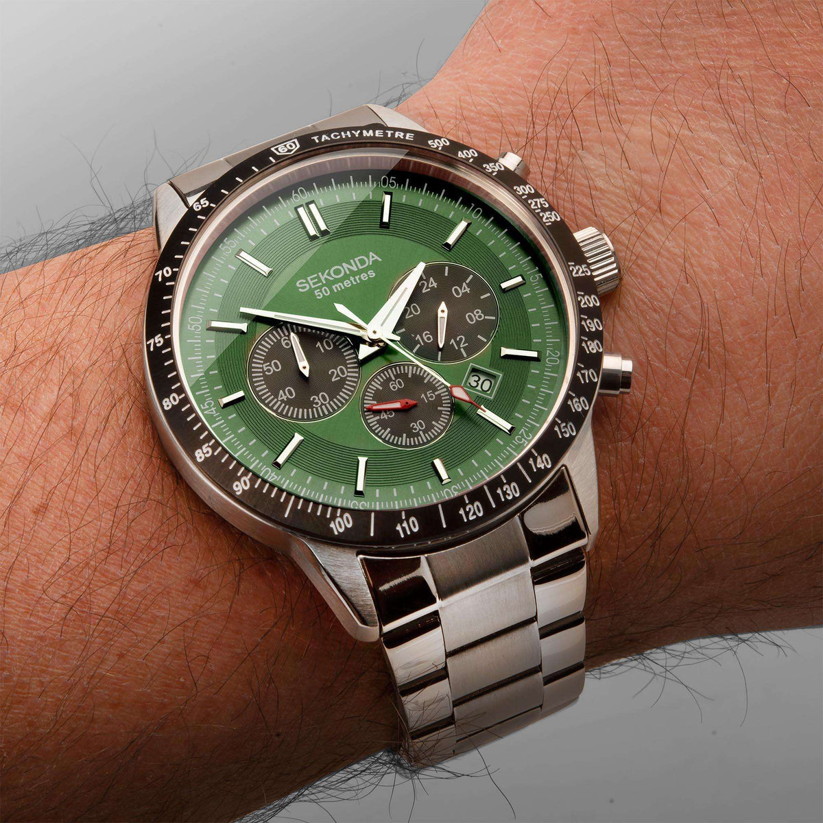 Men's stainless chronograph on wrist with green dial and black tachymeter bezel