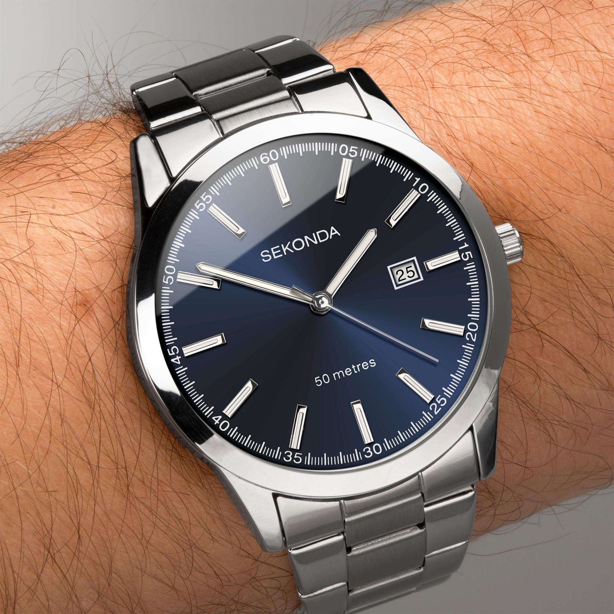 Men's stainless steel watch on wrist, dark blue dial with date window