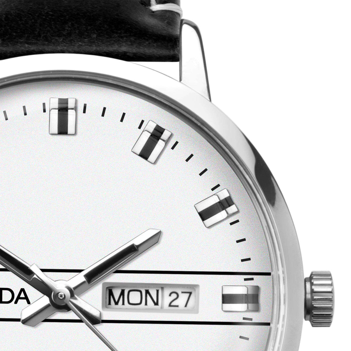 White watch dial close-up with silver hands, rectangular markers, and MON 27 date