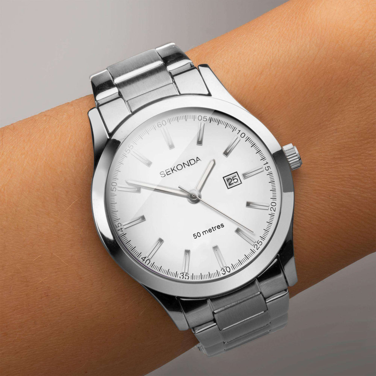 Ladies stainless steel watch on wrist, white dial with baton markers and date window