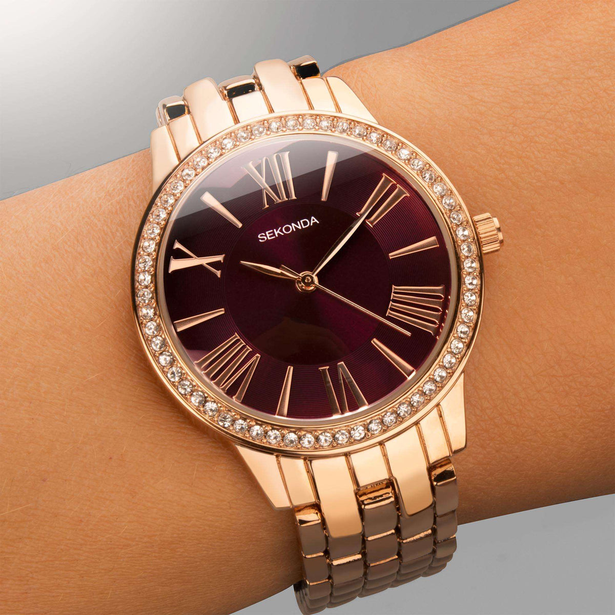 Sekonda Hero Quartz ladies watch on wrist, rose gold strap, burgundy dial, crystal bezel