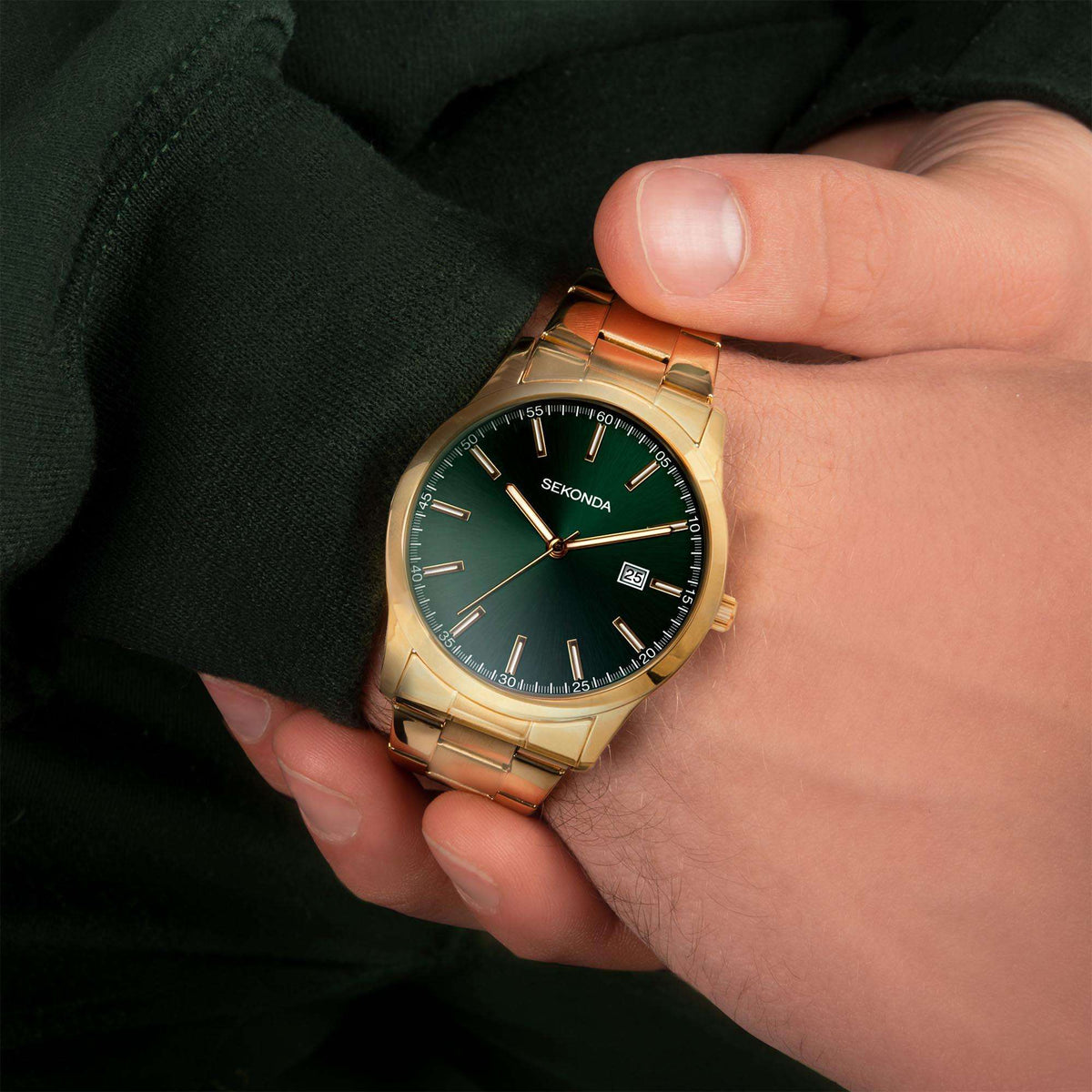 Men's gold-tone quartz wristwatch on hand, green dial with date window visible