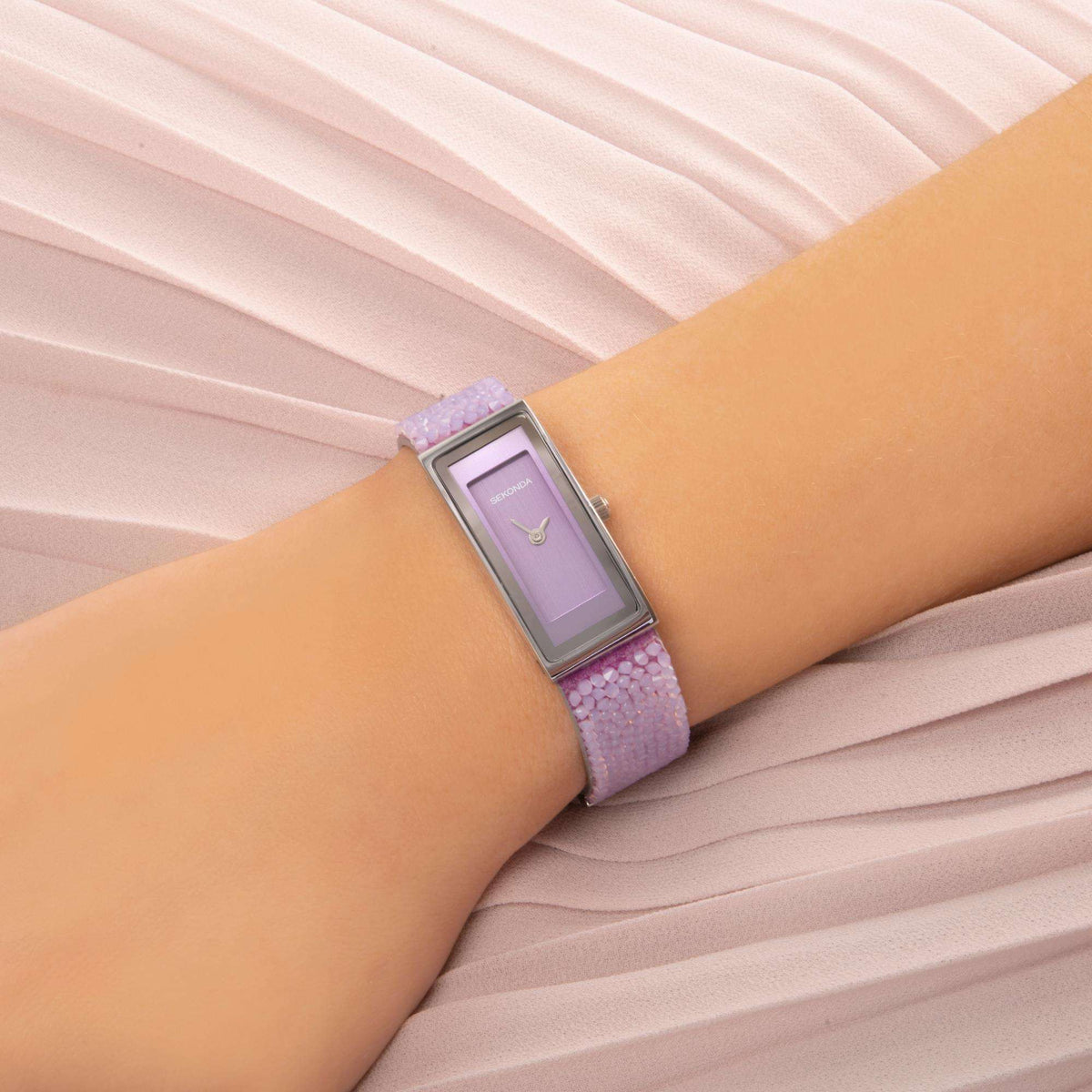 Sekonda ladies watch on wrist with lilac strap and rectangular lilac dial in silver case