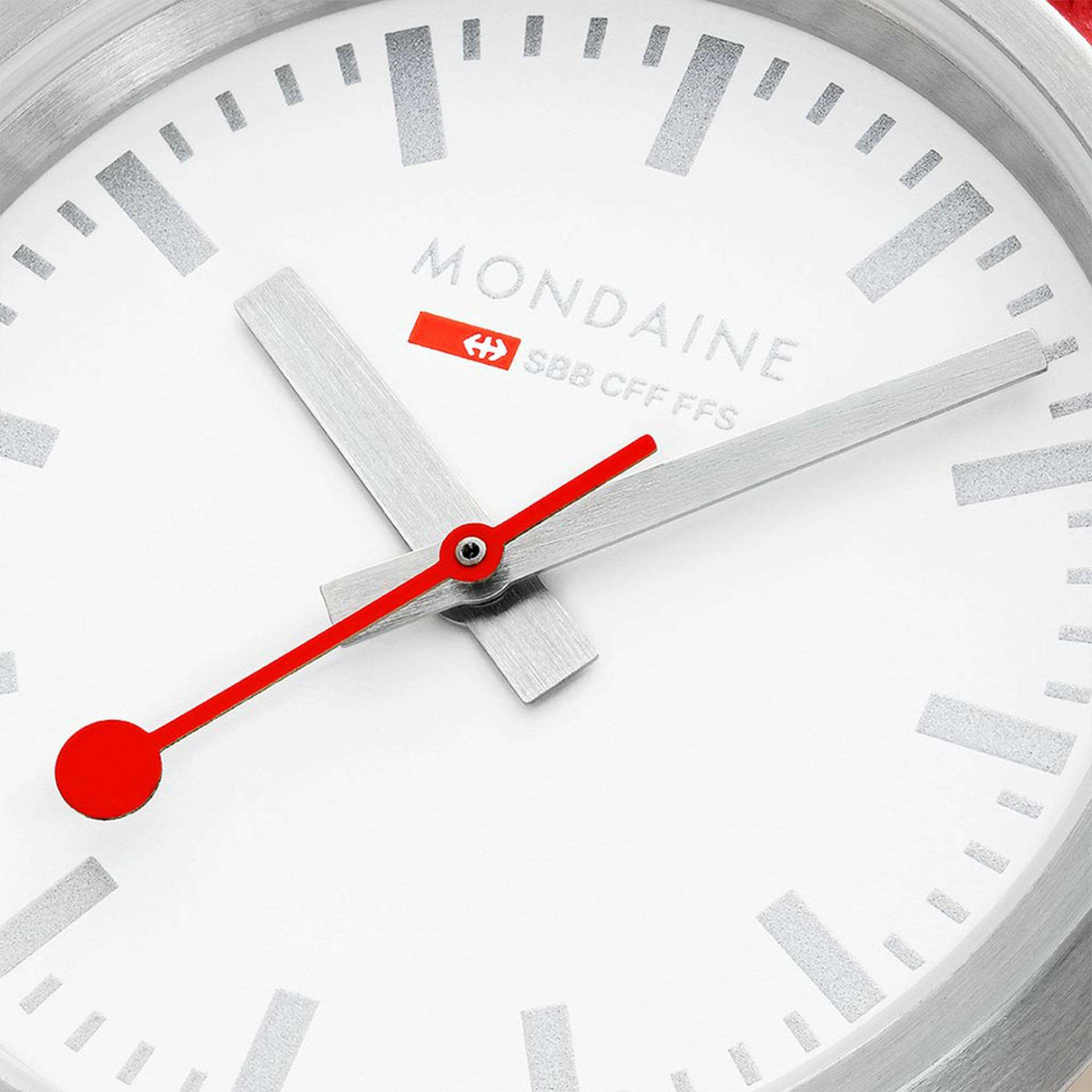 White watch dial close-up with red second hand and hour/minute markers