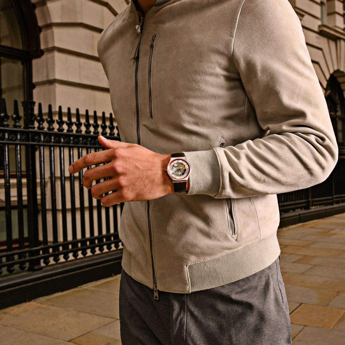 Mens skeleton dial quartz watch worn on wrist with dark leather strap and silver case