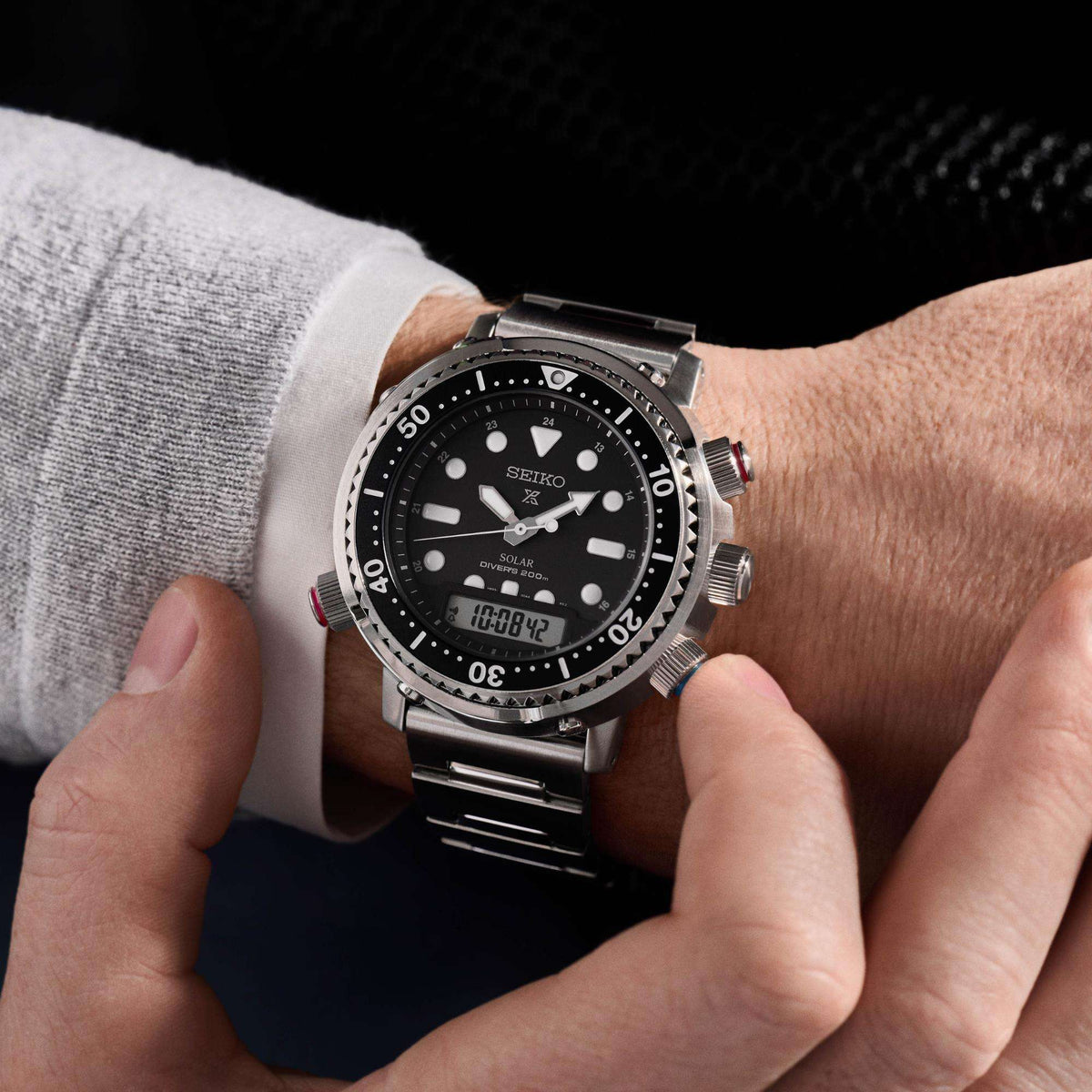 Mens wrist diver watch with black dial, silver case, and linked stainless steel bracelet