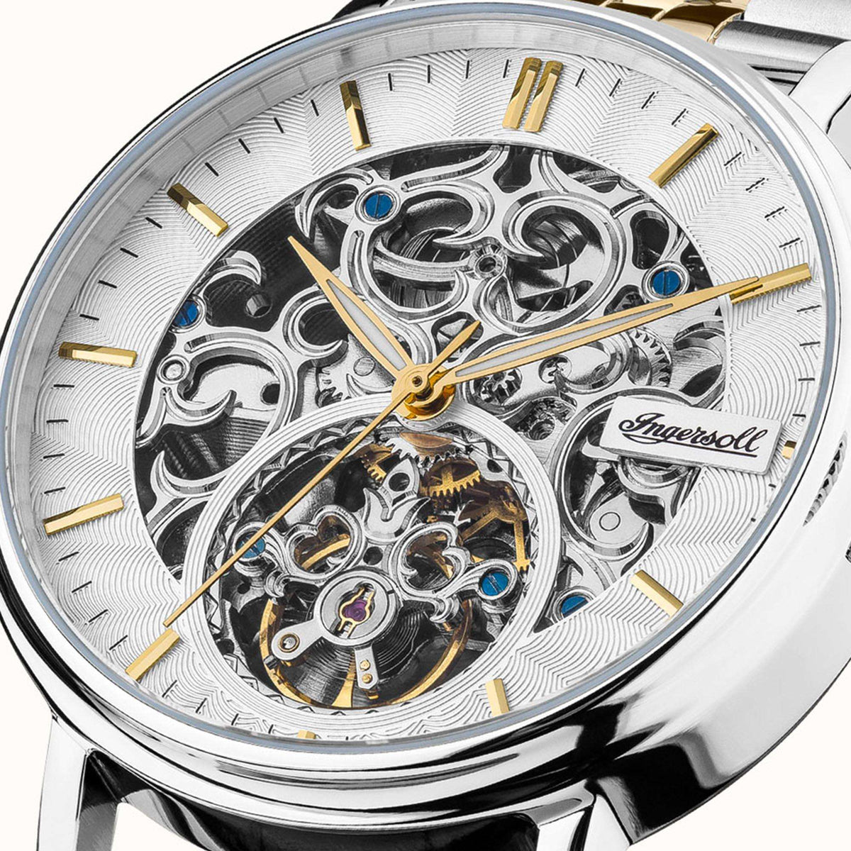 Close-up of silver skeleton dial with gold hands and exposed automatic movement