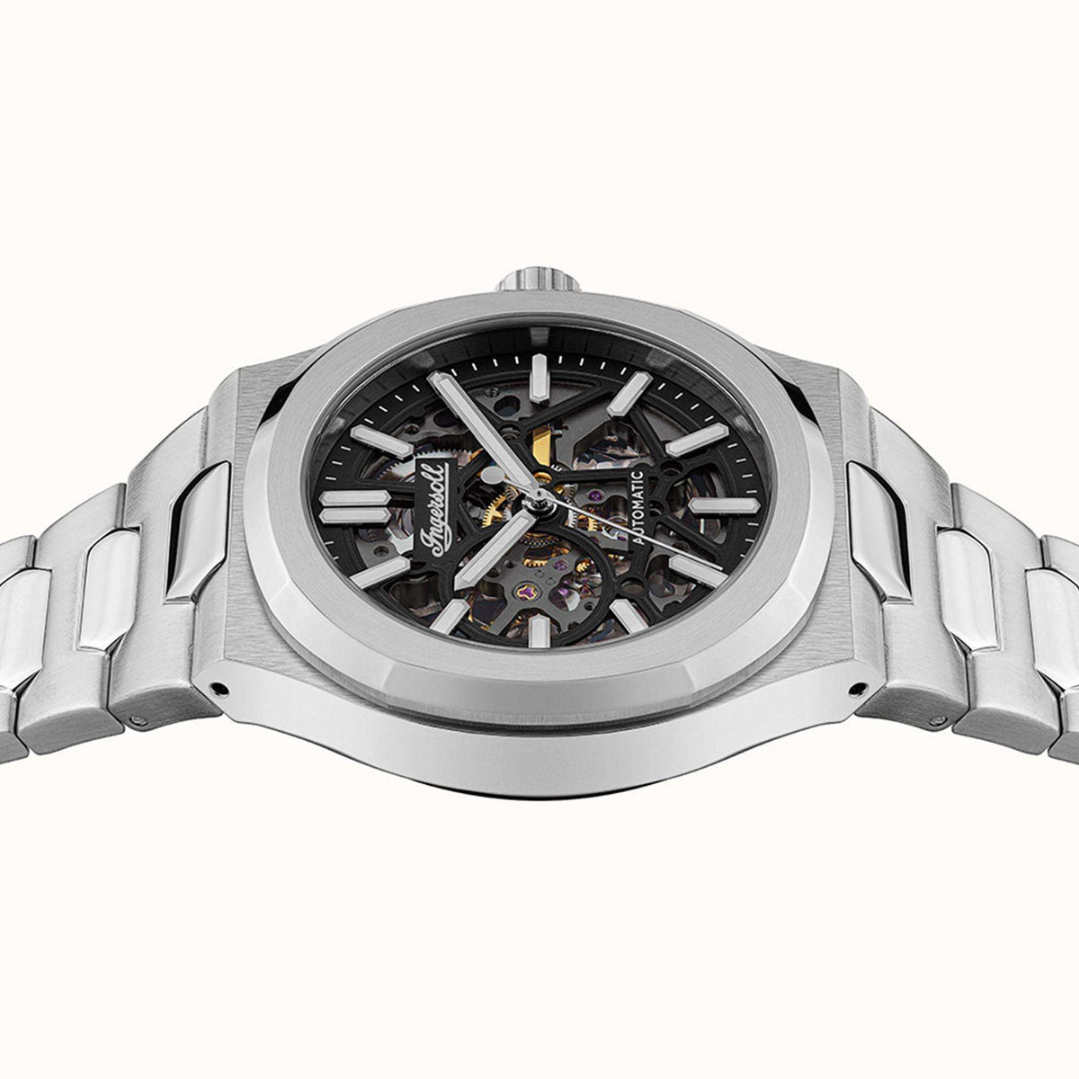 Men's automatic watch showing exposed movement through the glass case, stainless steel links.