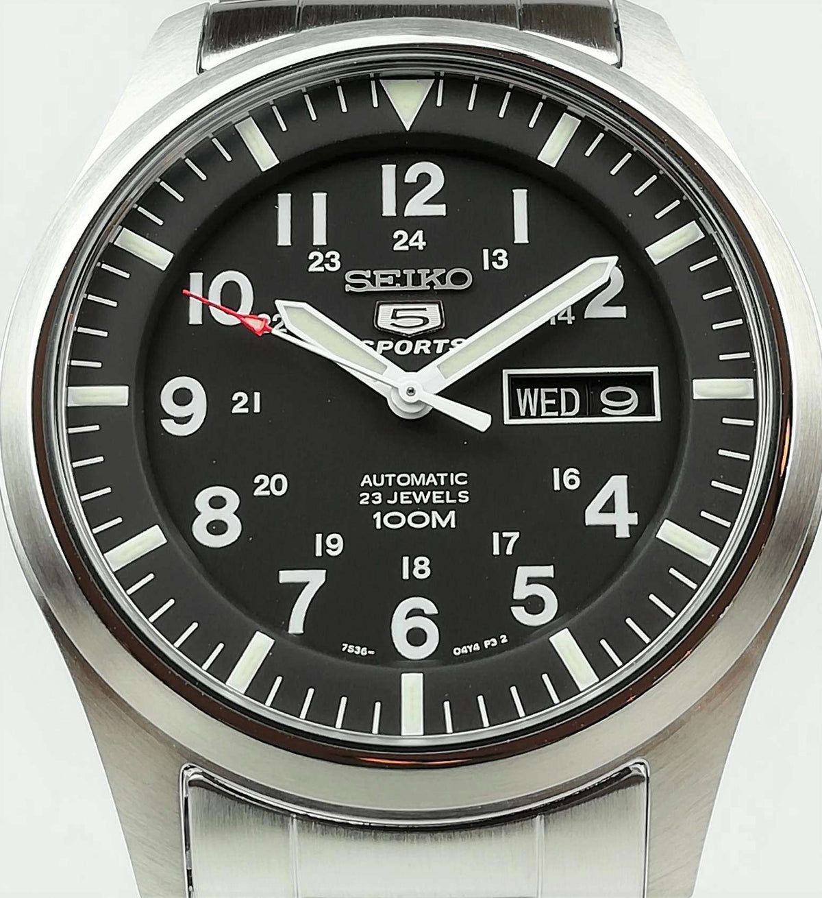 Men's Seiko 5 Sports watch closeup: black dial with day-date window and steel case