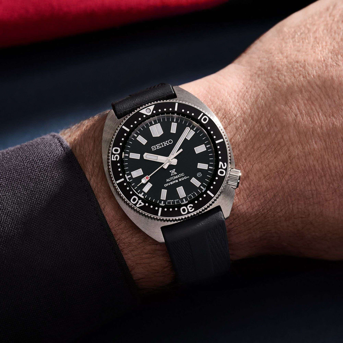 Seiko diver watch worn on wrist: black dial, stainless case, black rubber strap