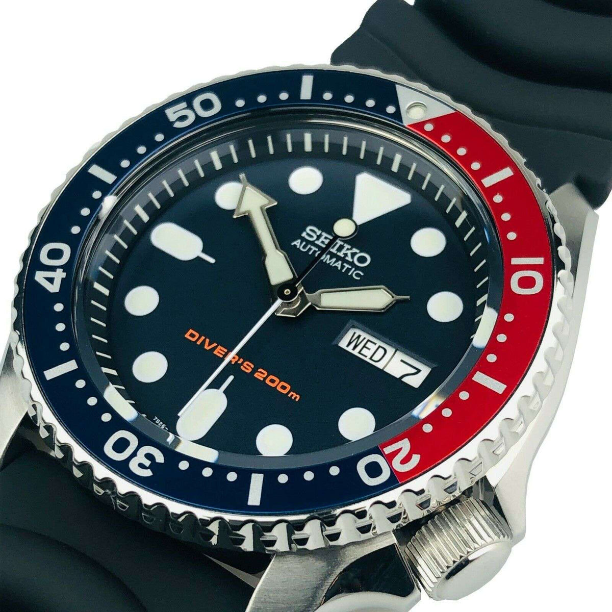 Men's automatic diver's watch close-up, black dial with markers, blue-red bezel, rubber strap
