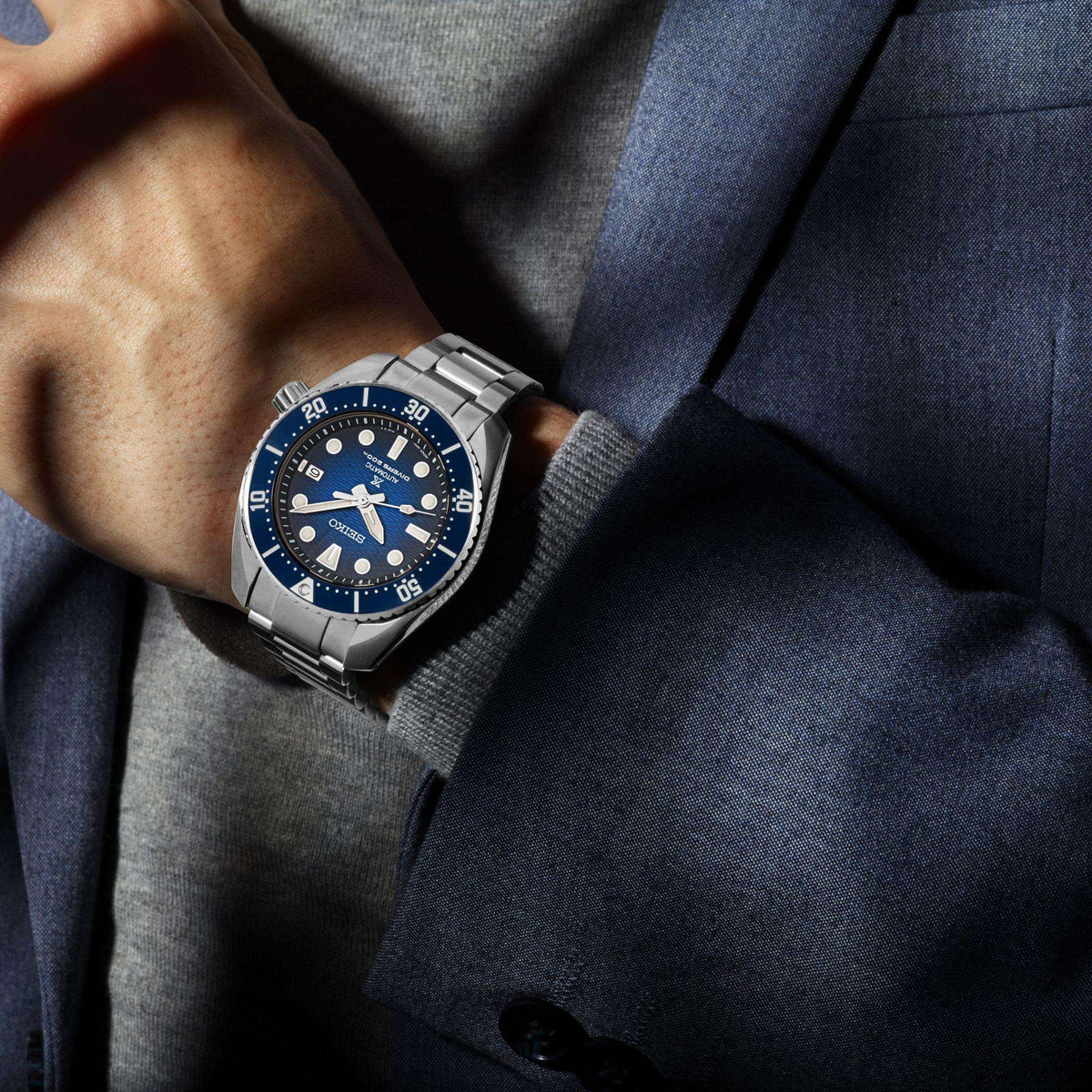 Seiko men's divers watch on wrist with blue dial, steel bracelet, and crown