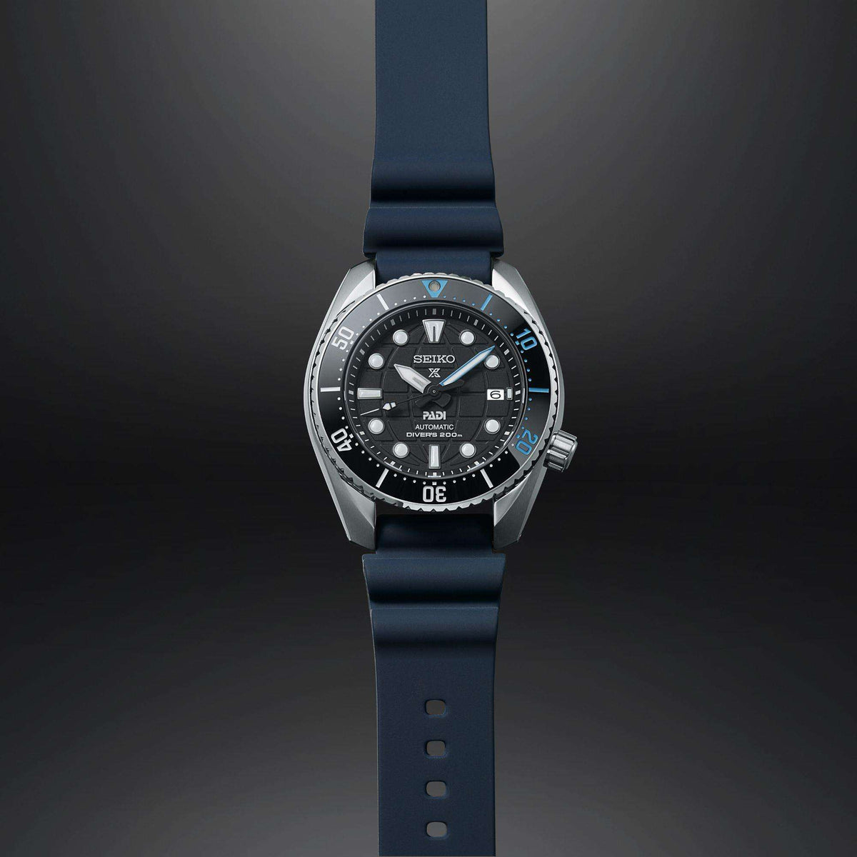 Seiko Prospex diver watch side profile with black dial, blue silicone strap, metal case